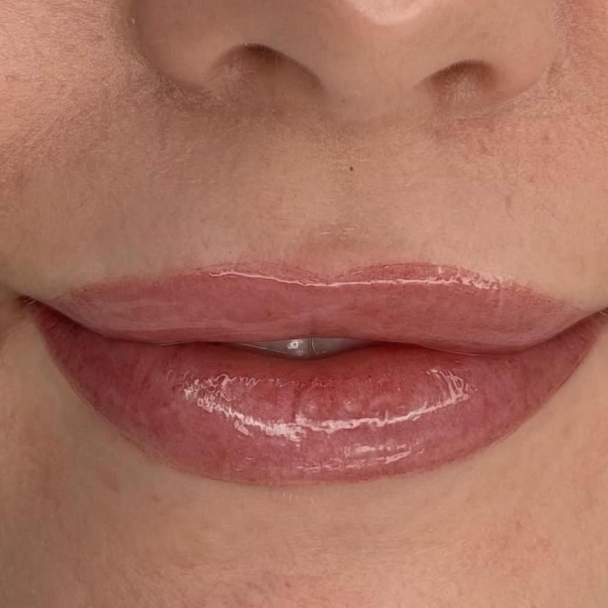 technician applying lip tattoo men close up
